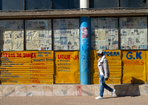 Angolan man walking in the city in front of a closed shop, Huila Province, Lubango, Angola