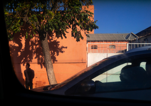 Angolan man driving a car in a sunny street, Huila Province, Lubango, Angola