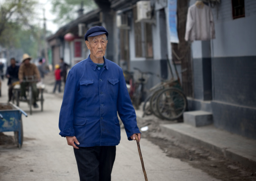 Chinese Man In Blue Clothes Walking With A Cane, Beijing China