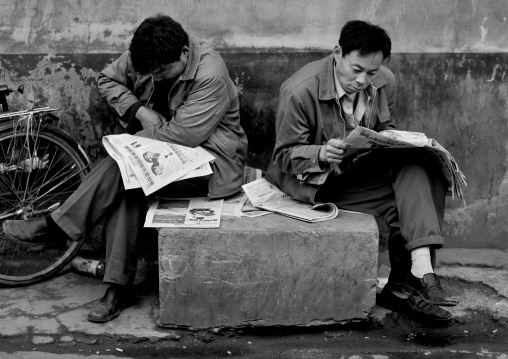 Men Reading Newspapers In A Hutong Street, Beijing China
