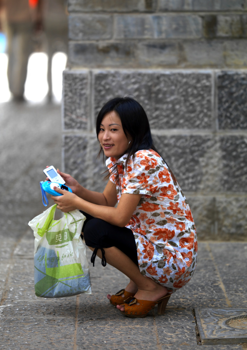 Young Woman With A Mobile Phone In The Street, Jianshui, Yunnan Province, China