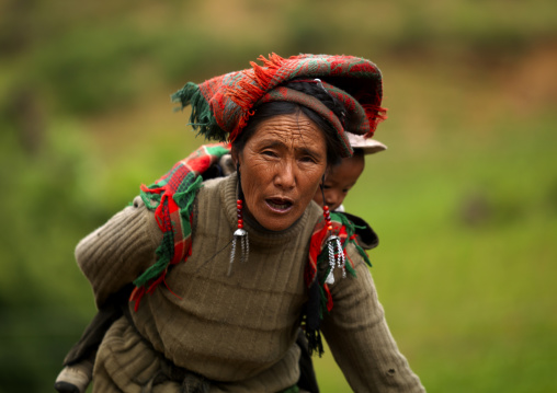 Woman Holding Her Baby In Her Back, Yongsheng, Yunnan Province, China
