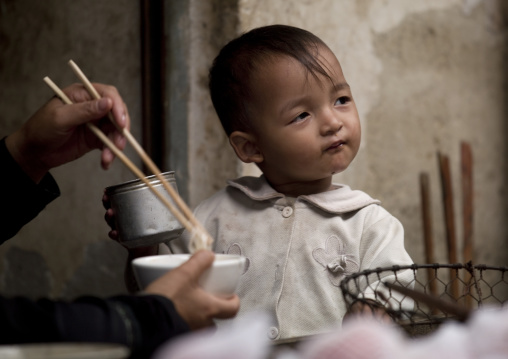 Kid Having A Meal On A Market, Yuanyang, Yunnan Province, China