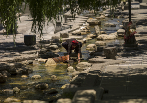 Woman Washing Clothes In Dali River, Dali, Yunnan Province, China