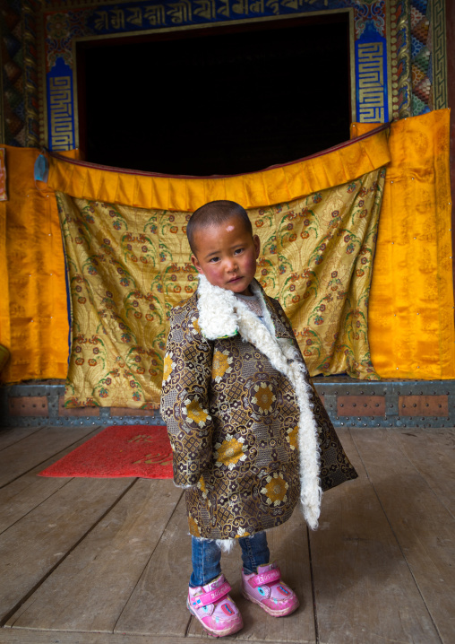 Tibetan child boy in traditional clothing in Shachong monastery, Qinghai Province, Wayaotai, China