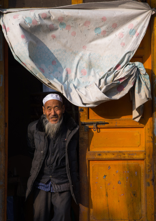 Salar ethnic minority old man at the entrance of his house, Qinghai Province, Xunhua, China