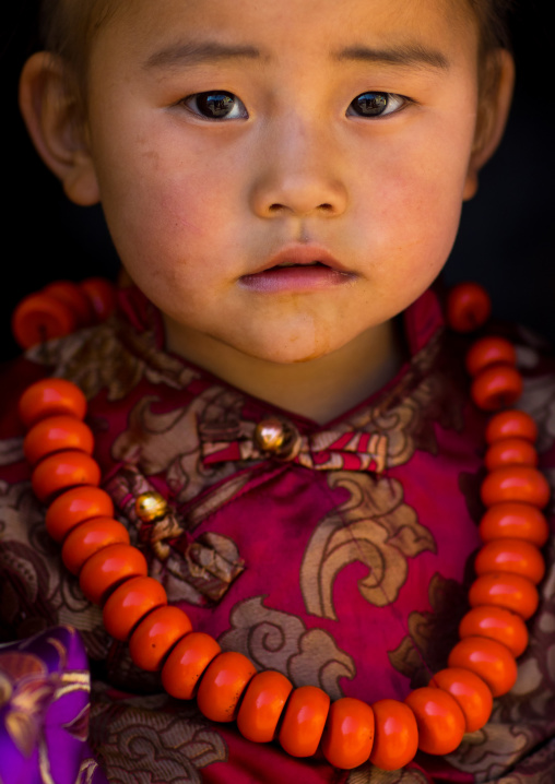 Tibetan child girl with a huge necklace, Tongren County, Rebkong, China
