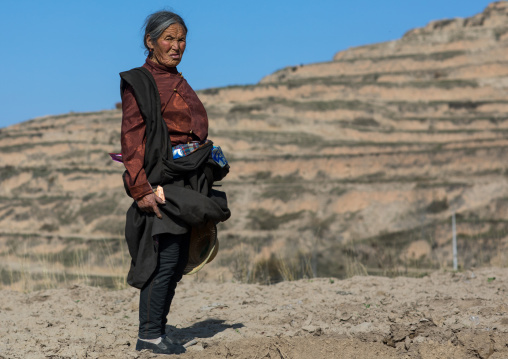 Old tibetan woman in the mountain, Tongren County, Rebkong, China