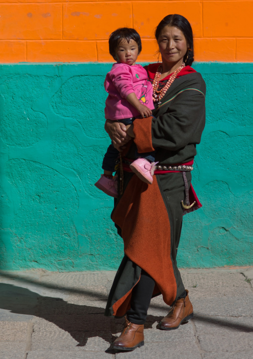Tibetan pilgrim mother with her child in Rongwo monastery, Tongren County, Longwu, China