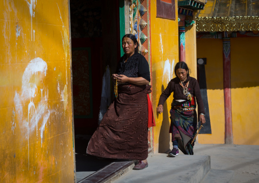 Tibetan women turning prayer wheels in a Rongwo monastery, Tongren County, Longwu, China