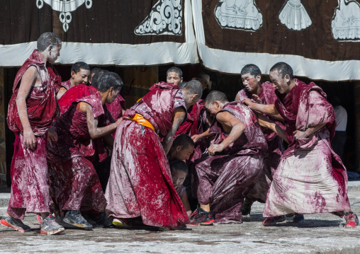 Tibetan monks enjoying a water fight after the yearly renovation of the Rongwo monastery, Tongren County, Longwu, China