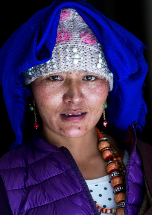 Portrait of a tibetan woman with a huge necklace and a headwear, Qinghai province, Tsekhog, China