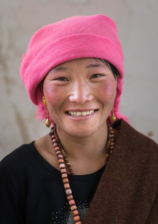 Portrait of a tibetan nomad woman with a pink headwear, Qinghai province, Tsekhog, China