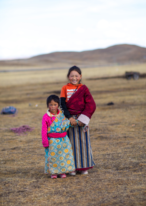 Portrait of a tibetan nomad children with their cheeks reddened by the harsh weather, Qinghai province, Tsekhog, China