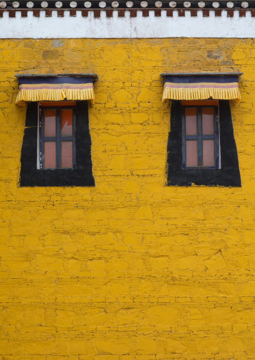 Typical tibetan windows on a yellow wall in Hezuo monastery, Gansu province, Hezuo, China