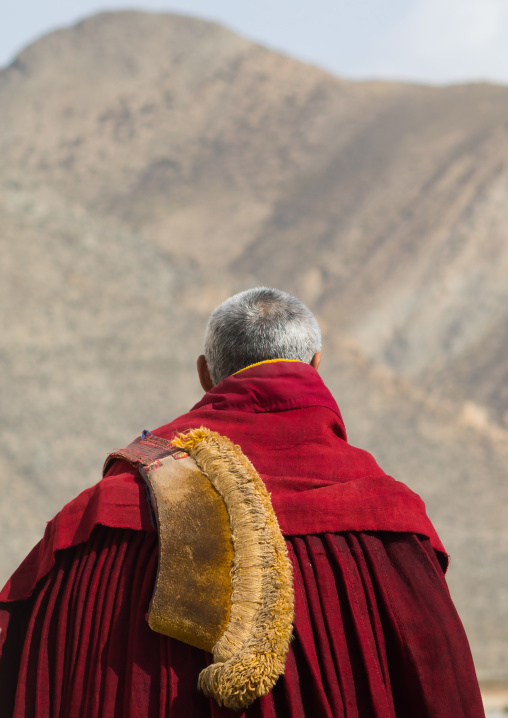 Tibetan monk wearing robe and yellow hat of the gelug order in Labrang monastery, Gansu province, Labrang, China