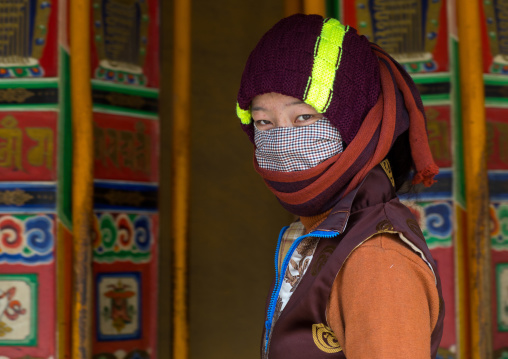 Tibetan pilgrim woman turning huge prayer wheels in Labrang monastery, Gansu province, Labrang, China