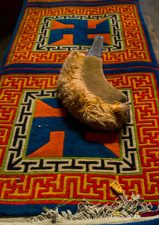 Yellow hat sect on a carpet with swastikas inside Bongya monastery, Qinghai province, Mosele, China