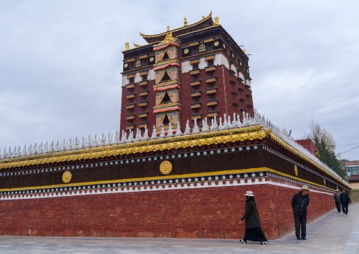 Tibetan pilgrim doing kora around Hezuo monastery and its milarepa tower, Gansu province, Hezuo, China