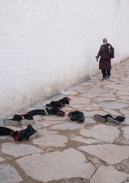 Tibetan monks boots in front of the entrance of a temple in Labrang monastery, Gansu province, Labrang, China