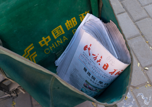 China post mewspapers in a delivery bicycle, Gansu province, Linxia, China