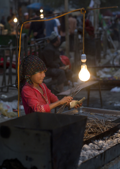 Young Uyghur Girl Preparing Skewers In The Night Market, Hotan, Xinjiang Uyghur Autonomous Region, China