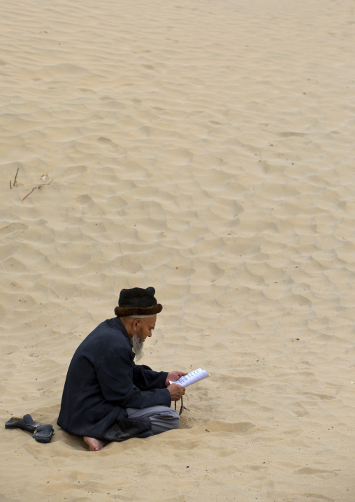 Uyghur Sufi Man Praying At Imam Asim Tomb In The Taklamakan Desert, Xinjiang Uyghur Autonomous Region, China