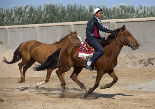 Young Uyghur Man Trying Out A Horse In Serik Buya Market, Yarkand, Xinjiang Uyghur Autonomous Region, China
