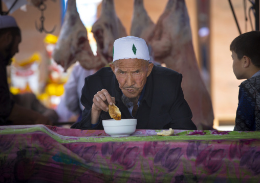 Old Uyghur Man Eating bread, Serik Buya Market, Yarkand, Xinjiang Uyghur Autonomous Region, China
