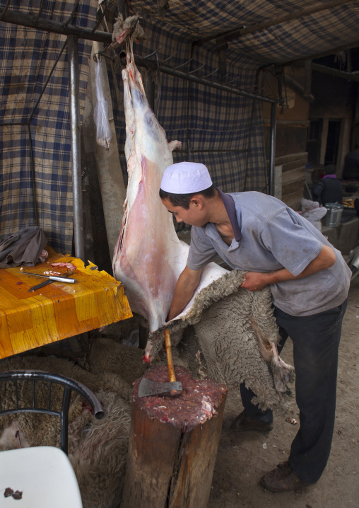 Young Uyghur Man Removing The Skin Of A Sheep, Keriya, Old Town, Xinjiang Uyghur Autonomous Region, China