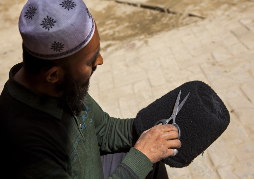 Uyghur Man Making A sheep skin Hat, Minfeng, Xinjiang Uyghur Autonomous Region, China