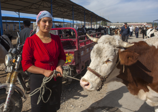 Young Uyghur Woman Showing her Cow, Serik Buya Market, Yarkand, Xinjiang Uyghur Autonomous Region, China