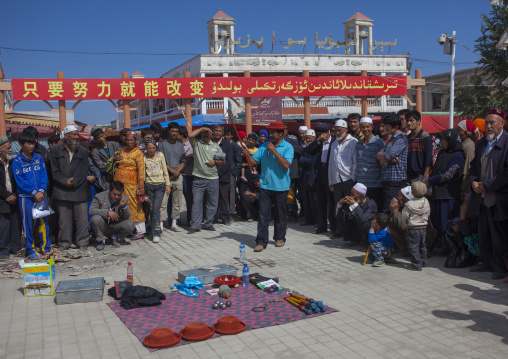Seller making a show, Serik Buya Market, Yarkand, Xinjiang Uyghur Autonomous Region, China
