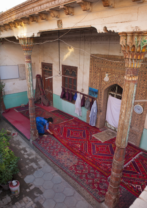 Uygur Woman Uncoiling The Carpets Of A Mosque, Old Town Of Kashgar, Xinjiang Uyghur Autonomous Region, China