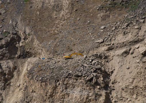 Yellow excavator working on amountain road, Badakhshan province, Darmadar, Afghanistan