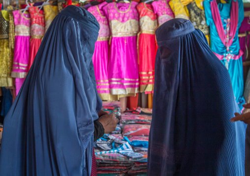 Women wearing burkas in the market byuing clothes, Badakhshan province, Ishkashim, Afghanistan