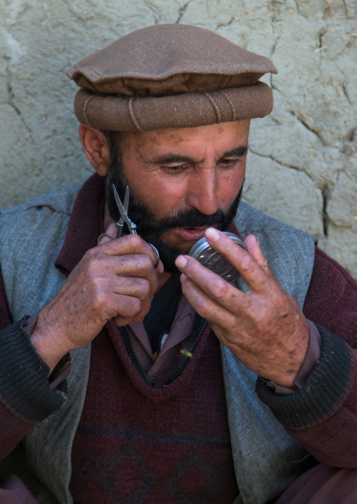 Afghan man cutting his beard in the street, Badakhshan province, Ishkashim, Afghanistan