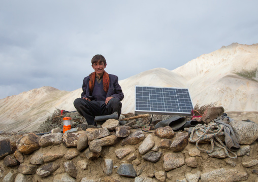 Wakhi nomad teenager sitting near a solar panel, Big pamir, Wakhan, Afghanistan