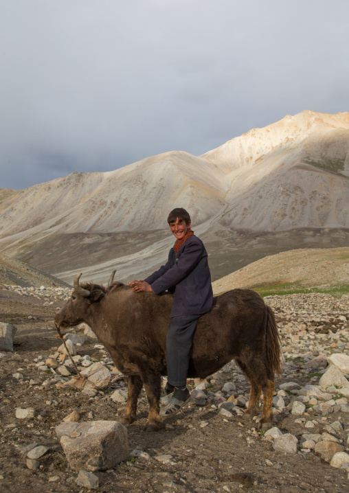Wakhi teenage boy riding a yak, Big pamir, Wakhan, Afghanistan