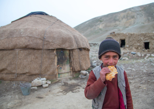 Wakhi nomad boy eating bread in front of his yurt, Big pamir, Wakhan, Afghanistan