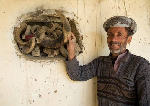 Afghan man showing the ibex horns used during ramadan and nowruz celebrations, Badakhshan province, Zebak, Afghanistan