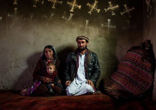 Afghan family inside their traditional pamiri house with the walls decorated for nowruz, Badakhshan province, Zebak, Afghanistan