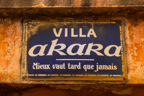 Benin, West Africa, Porto-Novo, villa akara panel with the name of the house and a french proverb below "better late than never"