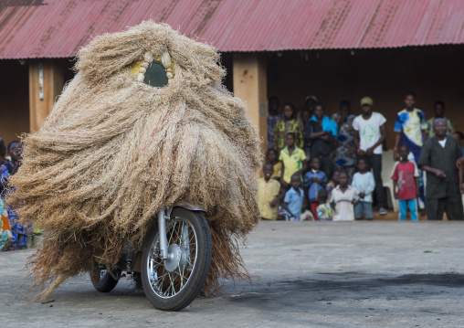 Benin, West Africa, Porto-Novo, zangbeto guardian of the night spirit riding motorcycle in the royal palace
