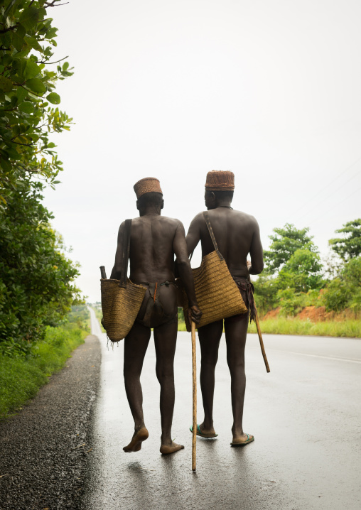 Benin, West Africa, Taneka-Koko, traditional healers walking on a concrete road
