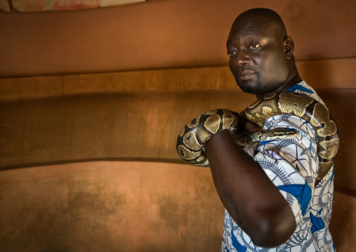 Benin, West Africa, Ouidah, man holding a snake in the python temple