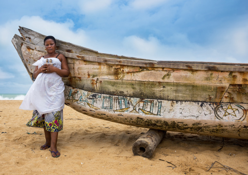 Benin, West Africa, Ouidah, mrs kpsouayo carrying the carved wooden figures made to house the soul of her dead twins