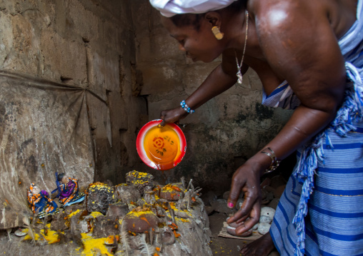 Benin, West Africa, Bopa, miss hounyoga putting oil in the deity dan temple for the voodoo dead twins cult