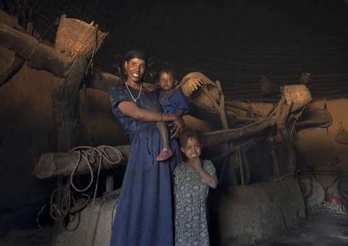 Portrait of a mother and kids in their tukul house, Alaba, Ethiopia
