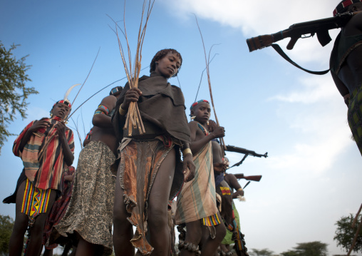 Banna Women Walking With Whips And Kalashnikov Rifles At  Bull Jumping Ceremony Ethiopia